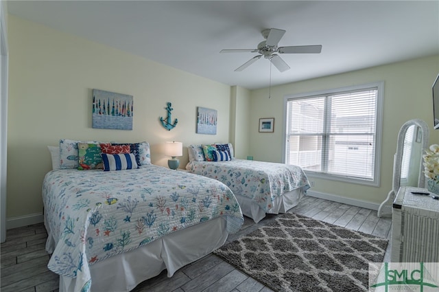 bedroom featuring ceiling fan, baseboards, and wood finished floors