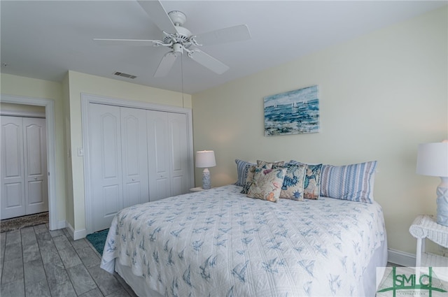 bedroom featuring wood finished floors, visible vents, a ceiling fan, and baseboards