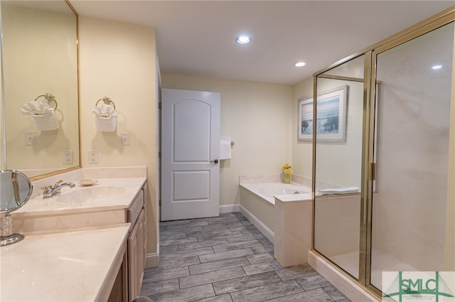 bathroom with a garden tub, wood tiled floor, a stall shower, vanity, and recessed lighting