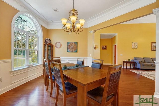 dining room featuring wood finished floors, visible vents, a wealth of natural light, and a notable chandelier