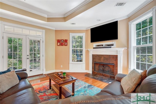 living room with crown molding, french doors, wood finished floors, and visible vents