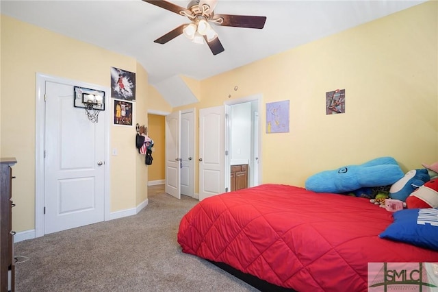 carpeted bedroom featuring lofted ceiling, baseboards, and ceiling fan