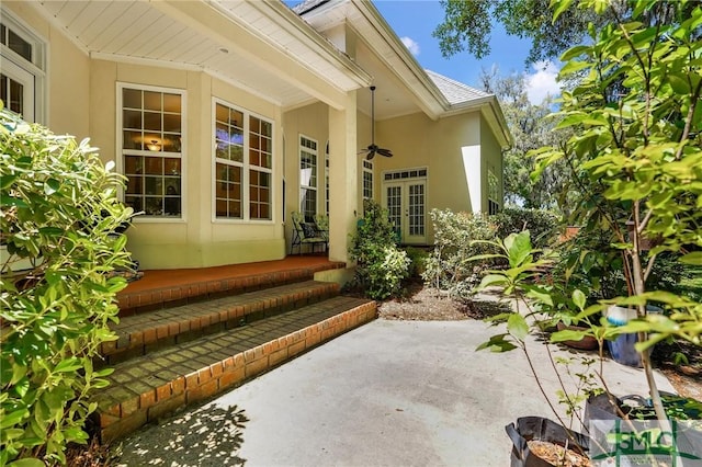 property entrance featuring stucco siding, a ceiling fan, and a patio