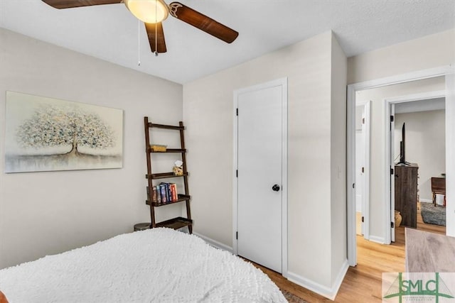 bedroom featuring light wood-style floors, baseboards, and ceiling fan