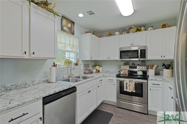 209 Bull St, Glennville, GA 30427 - kitchen with a sink, visible vents, white cabinetry, wood finished floors, and appliances with stainless steel finishes