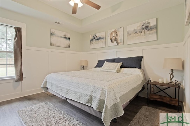 209 Bull St, Glennville, GA 30427 - bedroom featuring wood finished floors, a decorative wall, multiple windows, and visible vents