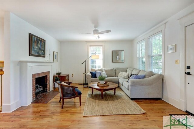402 E 56th St, Savannah, GA 31405 - living area with light wood finished floors, a ceiling fan, baseboards, and a brick fireplace