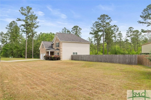 530 Briarcrest Dr NE, Ludowici, GA 31316 - view of side of property featuring fence, a yard, driveway, and a garage