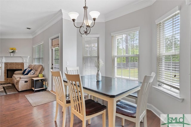 530 Briarcrest Dr NE, Ludowici, GA 31316 - dining room featuring wood finished floors, visible vents, crown molding, a fireplace, and a notable chandelier