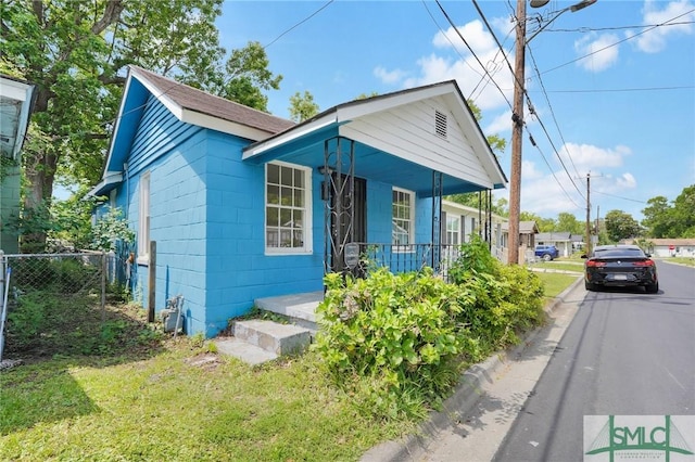 627 W 48th St, Savannah, GA 31405 - bungalow-style home with a front lawn, fence, concrete block siding, and covered porch