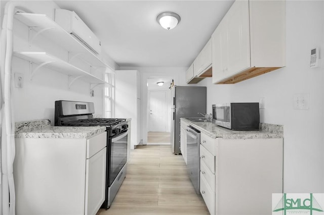 627 W 48th St, Savannah, GA 31405 - kitchen with white cabinets, light wood-style flooring, a sink, open shelves, and appliances with stainless steel finishes