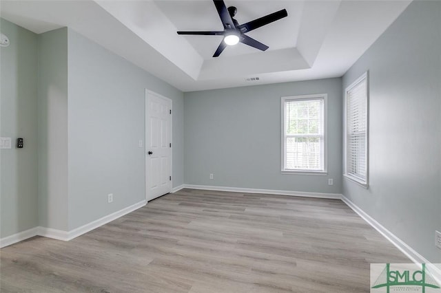 126 Four Oaks Ct, Rincon, GA 31326 - spare room featuring light wood-style flooring, a raised ceiling, ceiling fan, visible vents, and baseboards