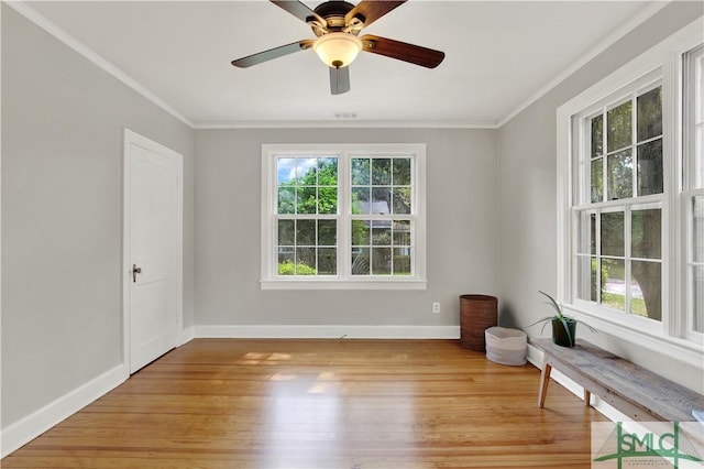 unfurnished room with baseboards, visible vents, light wood-style flooring, and crown molding