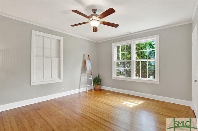 spare room featuring wood finished floors, visible vents, crown molding, and ceiling fan