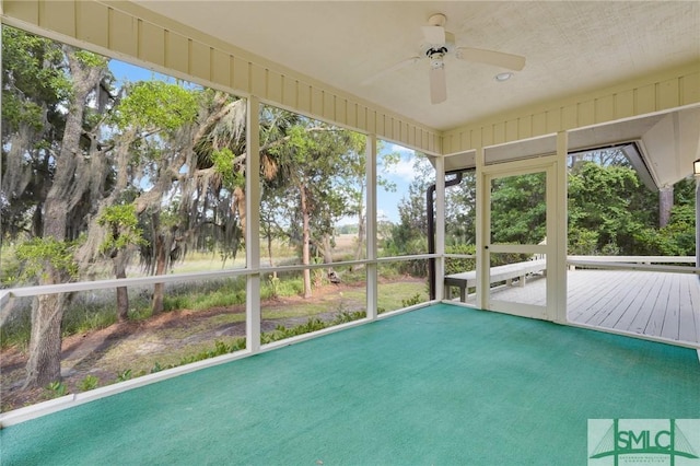 unfurnished sunroom with a ceiling fan