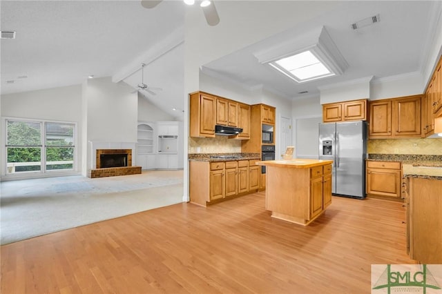 kitchen featuring a center island, open floor plan, a ceiling fan, under cabinet range hood, and black appliances