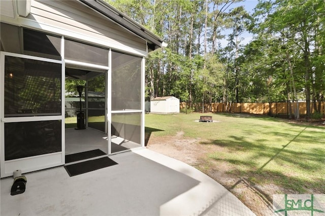 620 W 9th St, Rincon, GA 31326 - view of yard featuring a fenced backyard, a storage shed, a patio area, an outdoor fire pit, and a sunroom