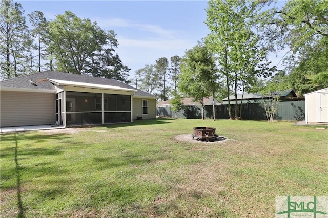620 W 9th St, Rincon, GA 31326 - view of yard featuring a shed, a fire pit, a fenced backyard, an outbuilding, and a sunroom