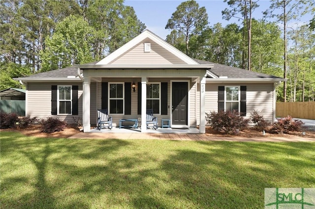 620 W 9th St, Rincon, GA 31326 - rear view of house featuring fence, a porch, roof with shingles, and a yard