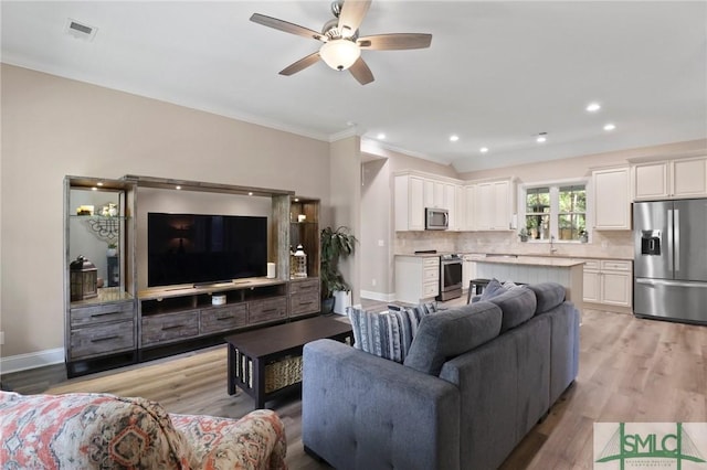 620 W 9th St, Rincon, GA 31326 - living area with ornamental molding, visible vents, light wood-style floors, and ceiling fan