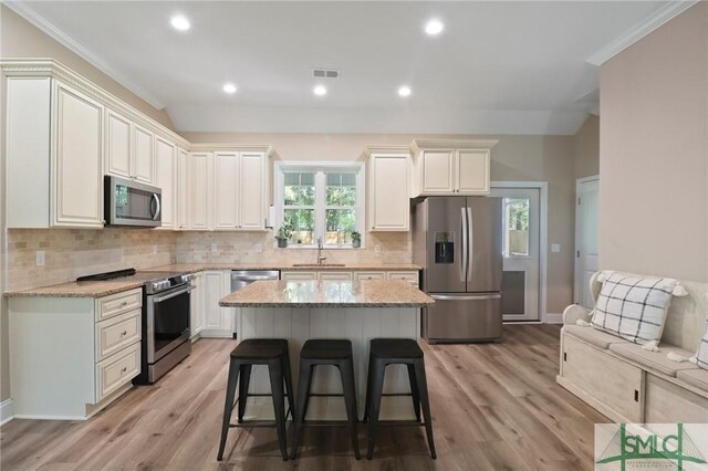 620 W 9th St, Rincon, GA 31326 - kitchen with light stone countertops, a kitchen breakfast bar, stainless steel appliances, and a sink