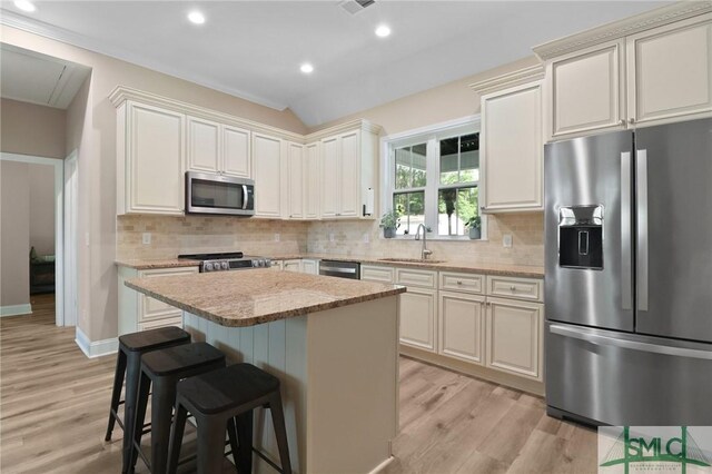 620 W 9th St, Rincon, GA 31326 - kitchen with a kitchen bar, a sink, light wood-style floors, and appliances with stainless steel finishes