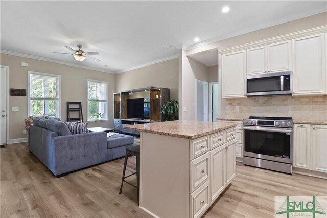 620 W 9th St, Rincon, GA 31326 - kitchen featuring light wood-type flooring, open floor plan, and appliances with stainless steel finishes