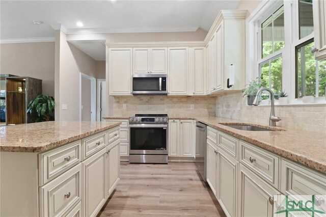 620 W 9th St, Rincon, GA 31326 - kitchen featuring light stone counters, backsplash, a sink, light wood-type flooring, and appliances with stainless steel finishes