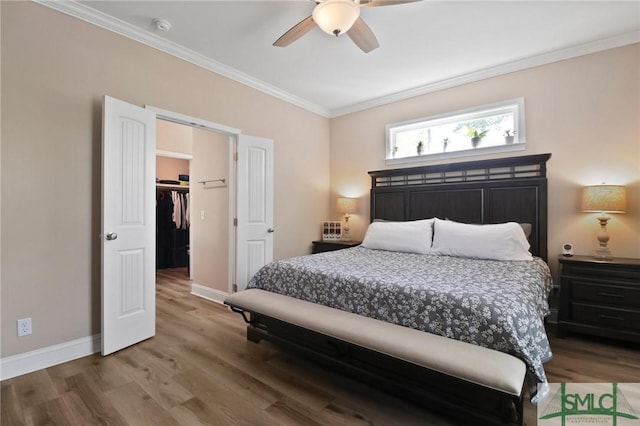 620 W 9th St, Rincon, GA 31326 - bedroom featuring crown molding, wood finished floors, a walk in closet, ceiling fan, and baseboards