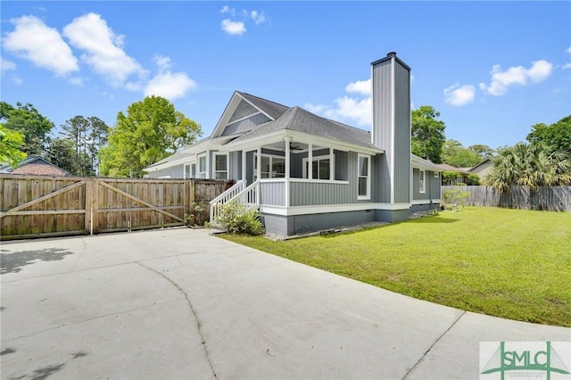 116 Rose Dhu Way, Savannah, GA 31419 - rear view of property featuring a chimney, a sunroom, a gate, and a ceiling fan