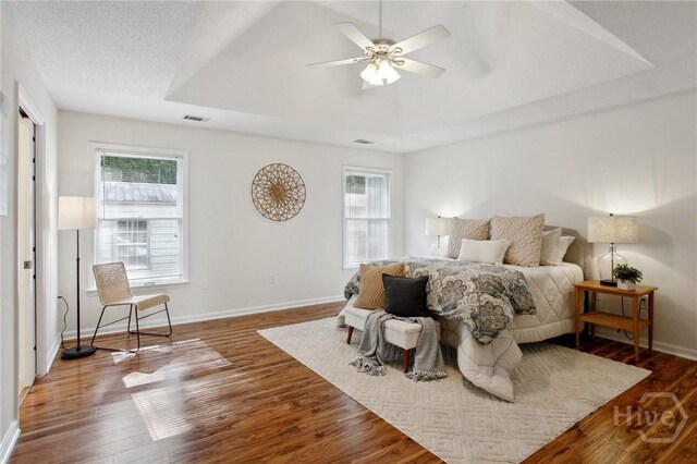 116 Rose Dhu Way, Savannah, GA 31419 - bedroom featuring multiple windows, a tray ceiling, wood finished floors, and a ceiling fan