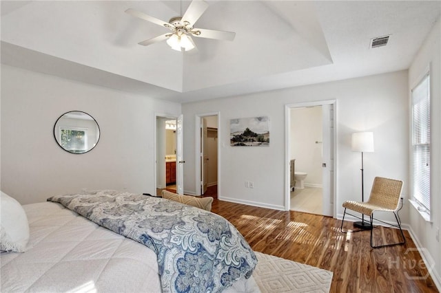116 Rose Dhu Way, Savannah, GA 31419 - bedroom with wood finished floors, ensuite bath, a walk in closet, a tray ceiling, and a ceiling fan