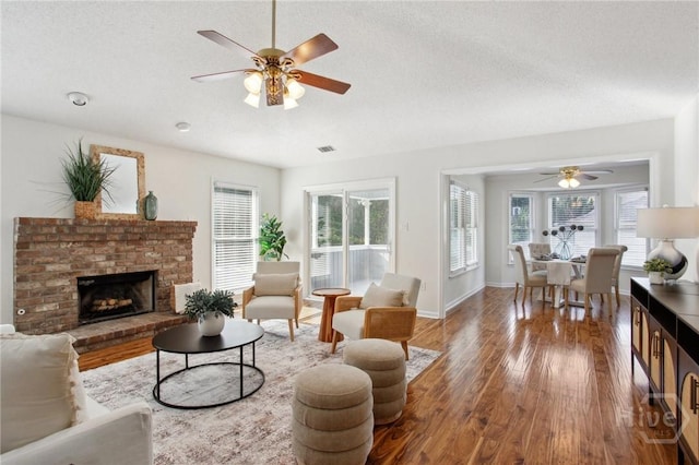 116 Rose Dhu Way, Savannah, GA 31419 - living room with a ceiling fan, wood finished floors, healthy amount of natural light, a brick fireplace, and a textured ceiling