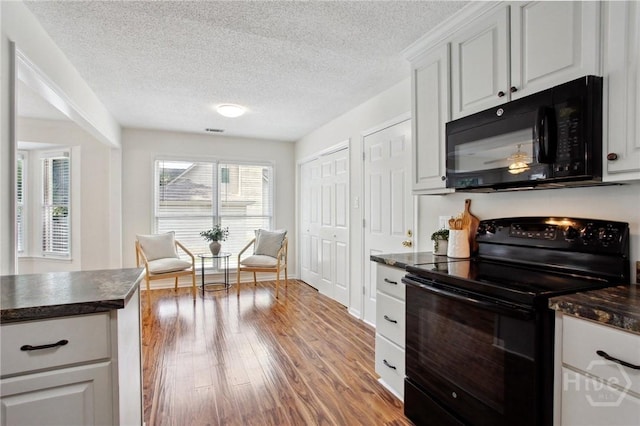 116 Rose Dhu Way, Savannah, GA 31419 - kitchen with black appliances, dark countertops, wood finished floors, a textured ceiling, and white cabinetry