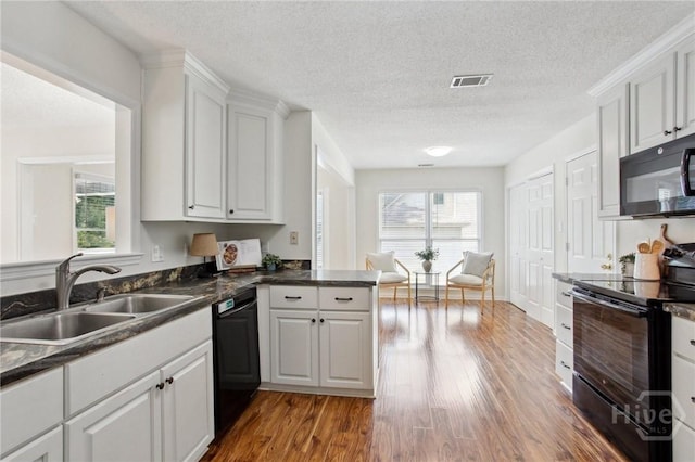 116 Rose Dhu Way, Savannah, GA 31419 - kitchen featuring black appliances, plenty of natural light, wood finished floors, white cabinetry, and a textured ceiling