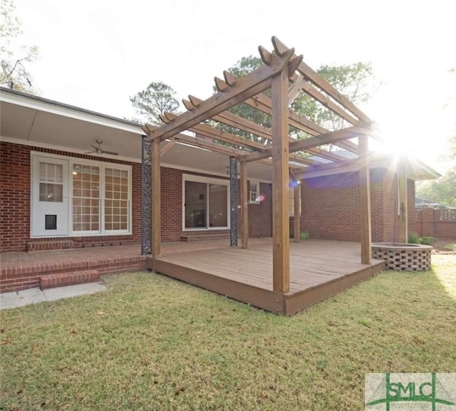 exterior space featuring a lawn, a deck, a pergola, and brick siding
