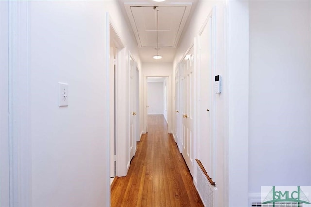 hallway featuring attic access, visible vents, and light wood-style flooring