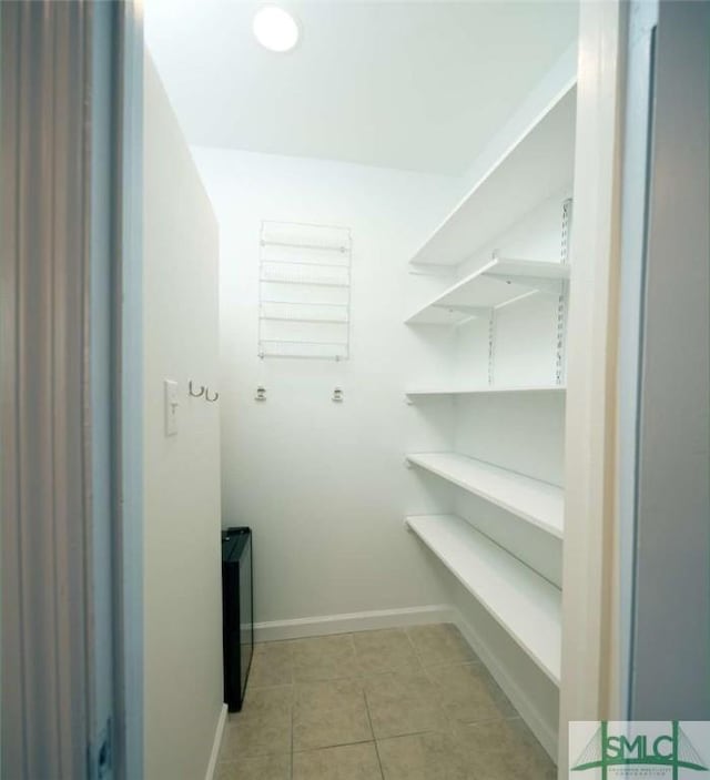 spacious closet with light tile patterned floors