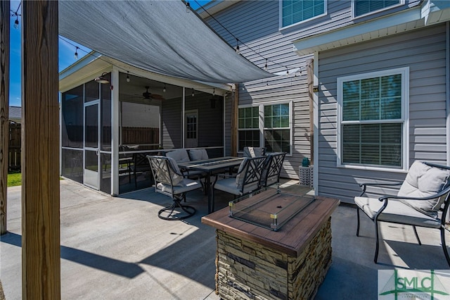 view of patio featuring outdoor dining space, a ceiling fan, and a sunroom