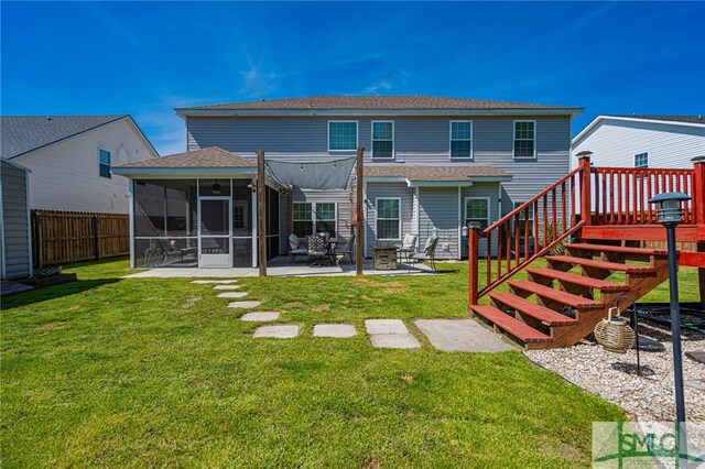 back of house with a lawn, roof with shingles, fence, and a sunroom