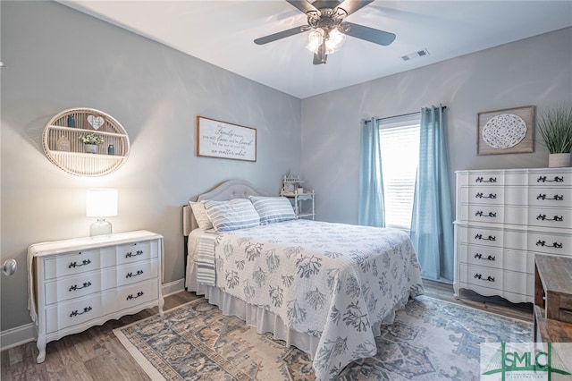 bedroom with wood finished floors, visible vents, ceiling fan, and baseboards