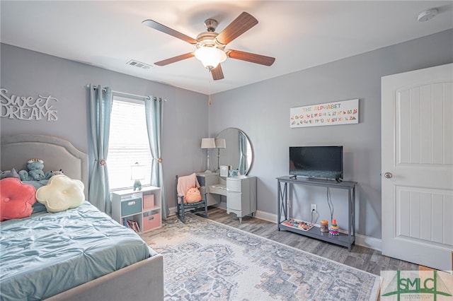 bedroom with wood finished floors, visible vents, and baseboards