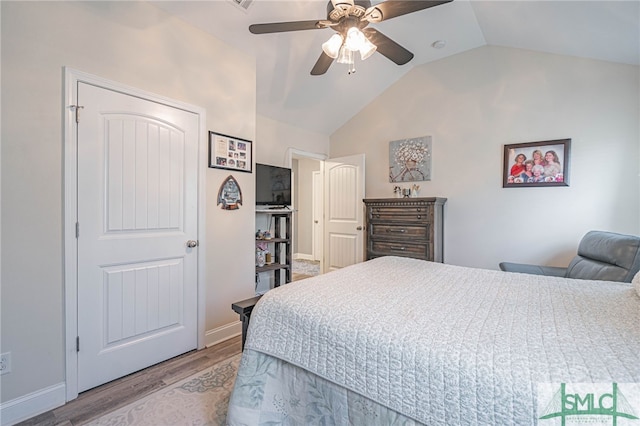 bedroom featuring light wood-style floors, a ceiling fan, vaulted ceiling, and baseboards