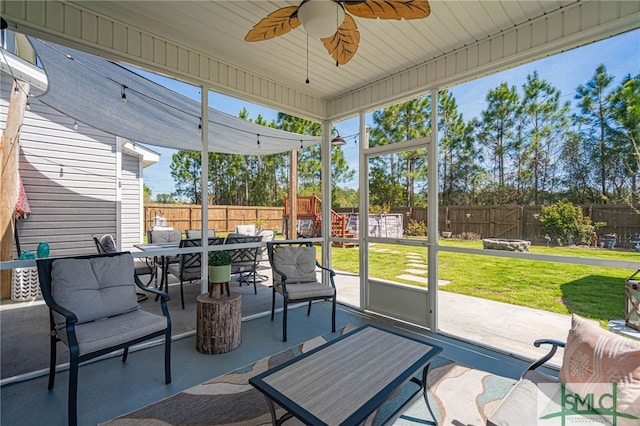 sunroom / solarium featuring ceiling fan and outdoor dining space