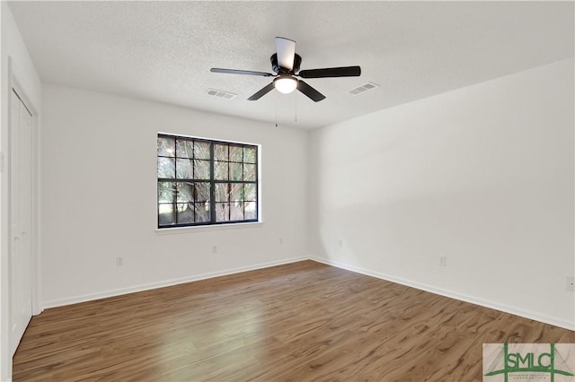 unfurnished bedroom with wood finished floors, visible vents, and baseboards