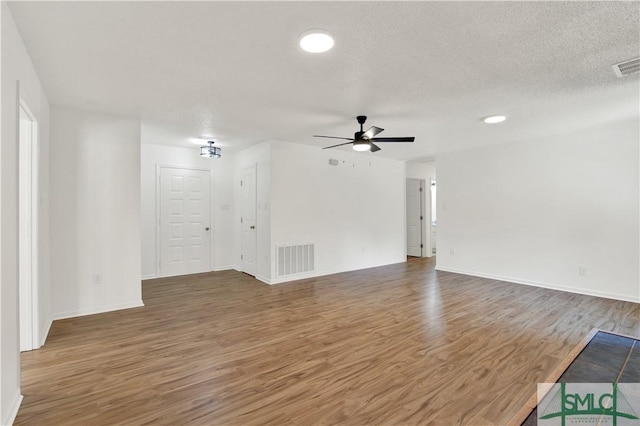unfurnished living room featuring baseboards, visible vents, wood finished floors, and a ceiling fan