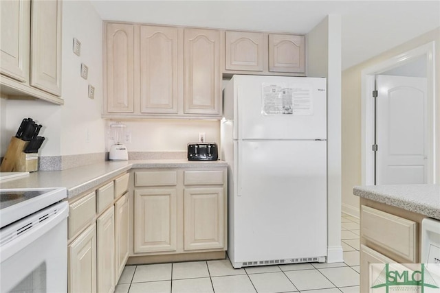 1609 Strand Ave Unit 206, Tybee Island, GA 31328 - kitchen featuring white appliances, light tile patterned flooring, light countertops, light brown cabinetry, and cream cabinetry