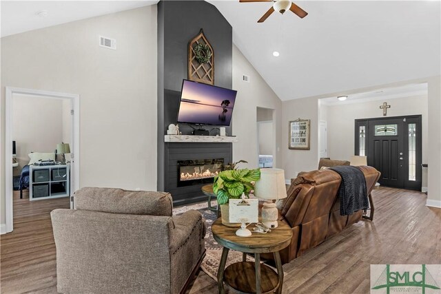 107 Mingledorff Way, Springfield, GA 31329 - living room with a large fireplace, high vaulted ceiling, a ceiling fan, visible vents, and wood finished floors