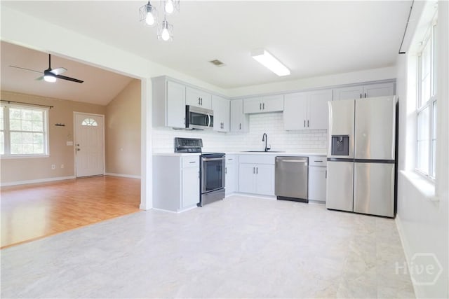 309 Wilkinson Rd NE, Ludowici, GA 31316 - kitchen featuring stainless steel appliances, a sink, open floor plan, decorative backsplash, and lofted ceiling
