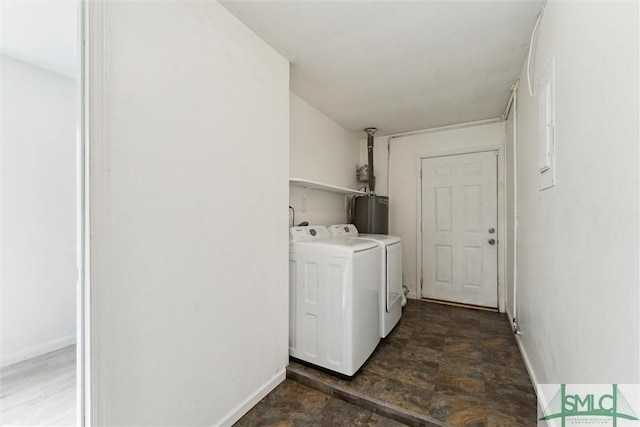 laundry area featuring laundry area, independent washer and dryer, stone finish floor, gas water heater, and baseboards